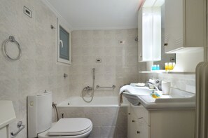 A modern bathroom with a toilet, bathtub, and sink. - Niovis a nice and cozy apartment (Athens)