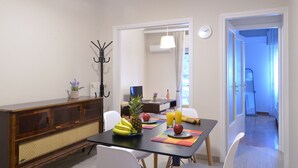A dining area with a table set for two, featuring fruits and a glass of orange juice. - Niovis a nice and cozy apartment (Athens)