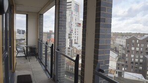 A balcony with a view of a cityscape, featuring tall buildings and a cloudy sky. - Toothbrush Apartments Waterfront - Adults Only (Ipswich)