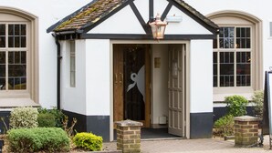 A white building with a sign reading "The Curious Pig in the Parish." - The Curious Pig in the Parlour  (Crawley)