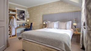 A bedroom with a large bed, a wooden wardrobe, a mirror, and a wall-mounted shelf with toiletries. - The Curious Pig in the Parlour  (Crawley)