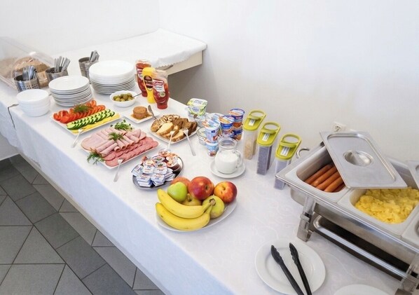 Una mesa de buffet con diversos alimentos, utensilios y salsas.