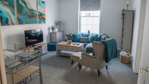 A modern living room with a TV, sofa, and coffee table. - Toothbrush Apartments - Central Ipswich - Fore St - Adults Only (Ipswich)