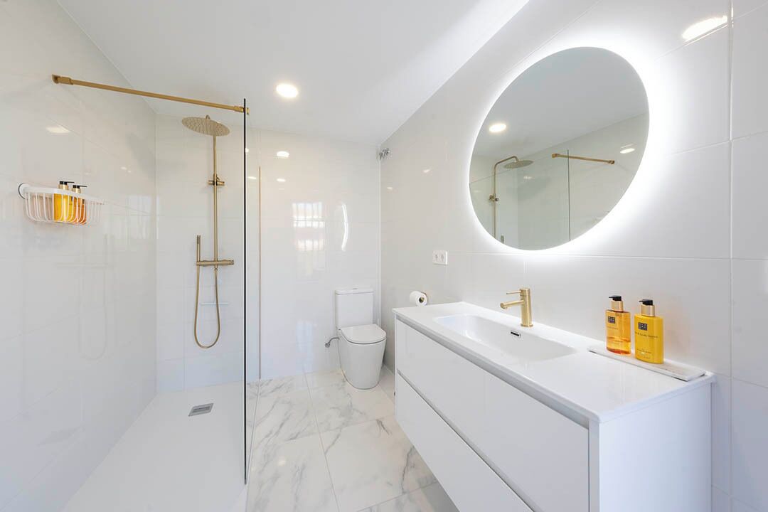 A modern bathroom with a walk-in shower, a large mirror, and a vanity with a sink.