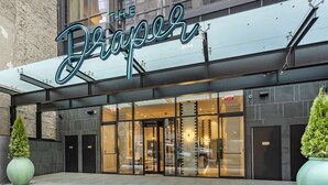 A modern building with a large sign reading "The Draper." - The Draper New York, Tapestry Collection by Hilton (New York)