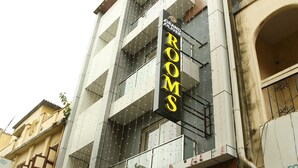 A hotel named "Grand Oliver" with a sign indicating "Rooms" and a visible car parked outside. - Grand Oliver (Chennai)