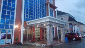 A building with large windows and a covered entrance area. - Newton Hotels Limited Owerri (Owerri)