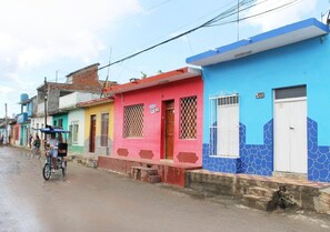 A street lined with colorful houses, each with a distinct color and a number on the door. - Hostal San Miguel TRINIDAD (Trinidad)
