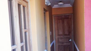 A narrow hallway with a wooden door and a window on the left. - Hostal Tony y Daisy TRINIDAD (Trinidad)