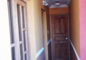 A narrow hallway with a wooden door and a window on the left. - Hostal Tony y Daisy TRINIDAD (Trinidad)