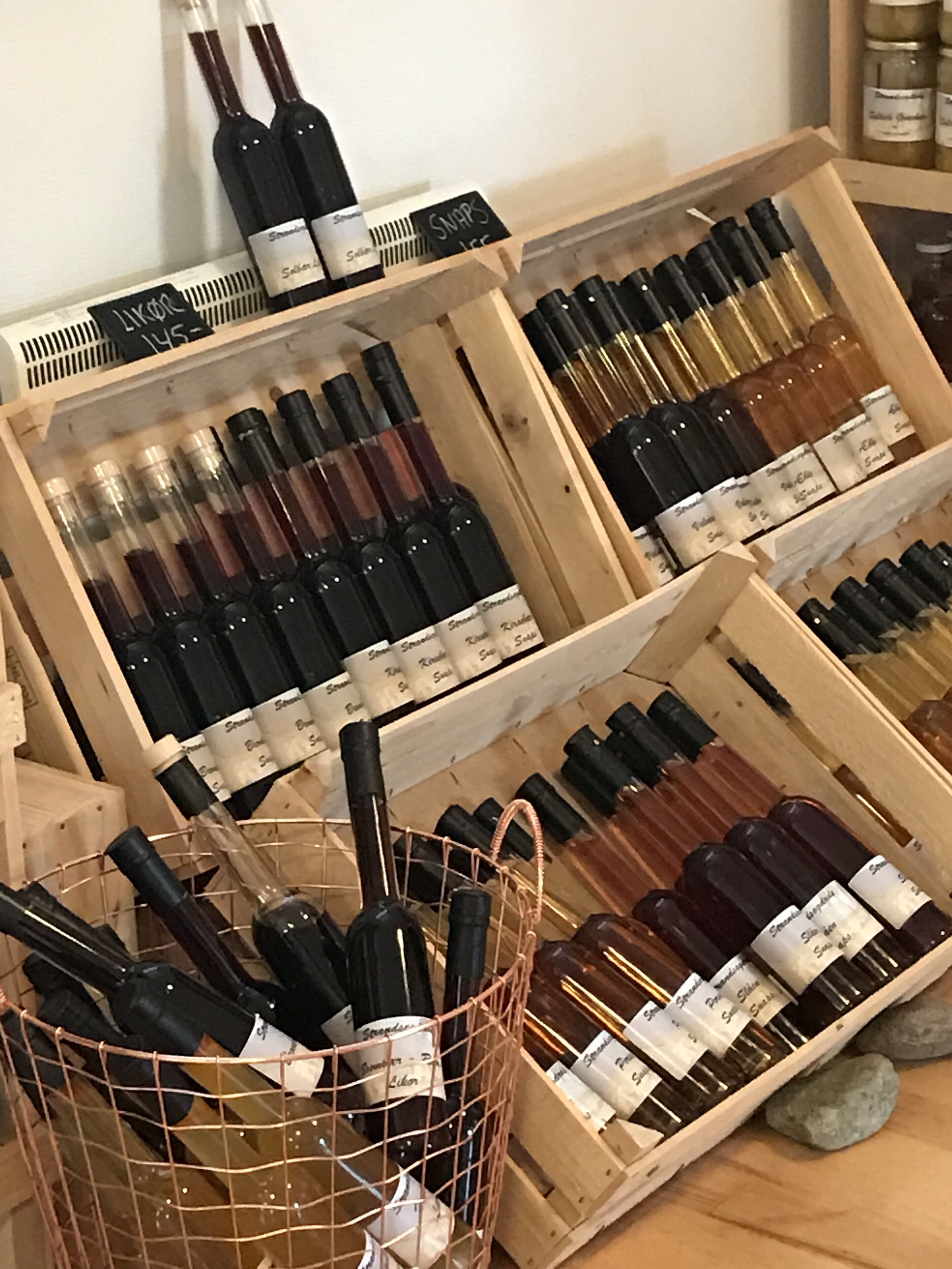 Wooden crates filled with wine bottles, some in wire baskets.