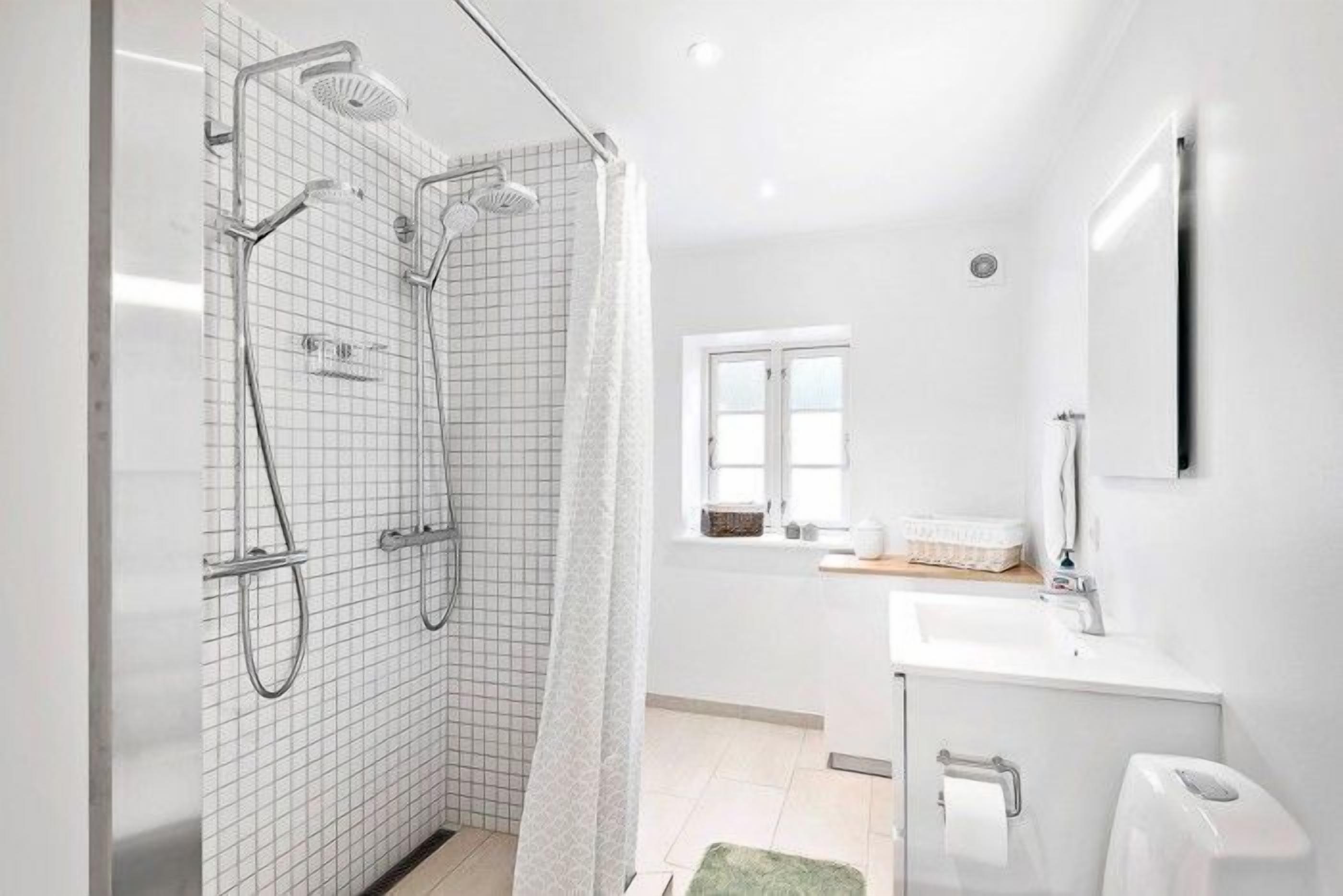 Een moderne badkamer met een douche, een wastafel en een toilet.