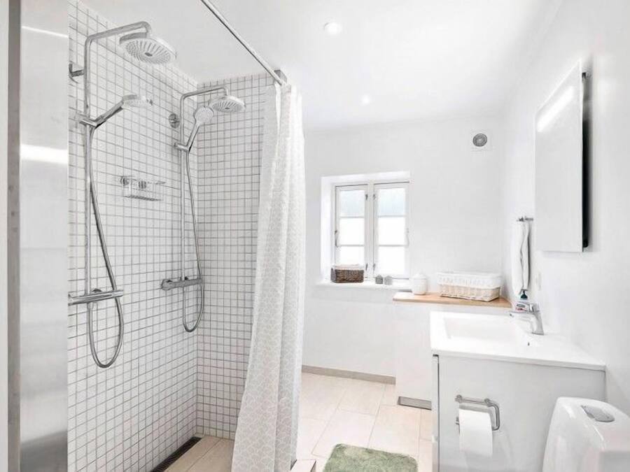 A modern bathroom with a shower, a sink, and a toilet.