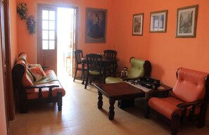 A living room with a sofa, chairs, a coffee table, and a dining table. - Sophi's House VEDADO (Havana)
