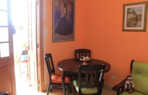 A dining area with a round table, four chairs, and a painting on the wall. - Sophi's House VEDADO (Havana)