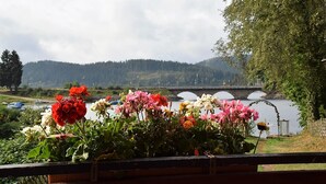 Arranjo floral com vista para uma ponte e colinas ao fundo.