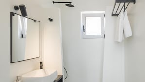 A modern bathroom with a freestanding bathtub, a large mirror, and a towel rack. - Paradiso II (Malevizi)