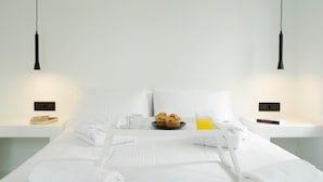 A neatly made bed with white linens, a tray with muffins, a cup, and a glass of orange juice. - Paradiso II (Malevizi)
