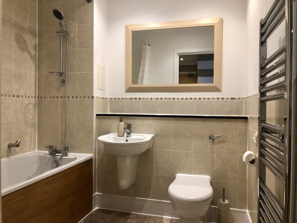 Un baño con bañera, lavabo, inodoro y ducha.