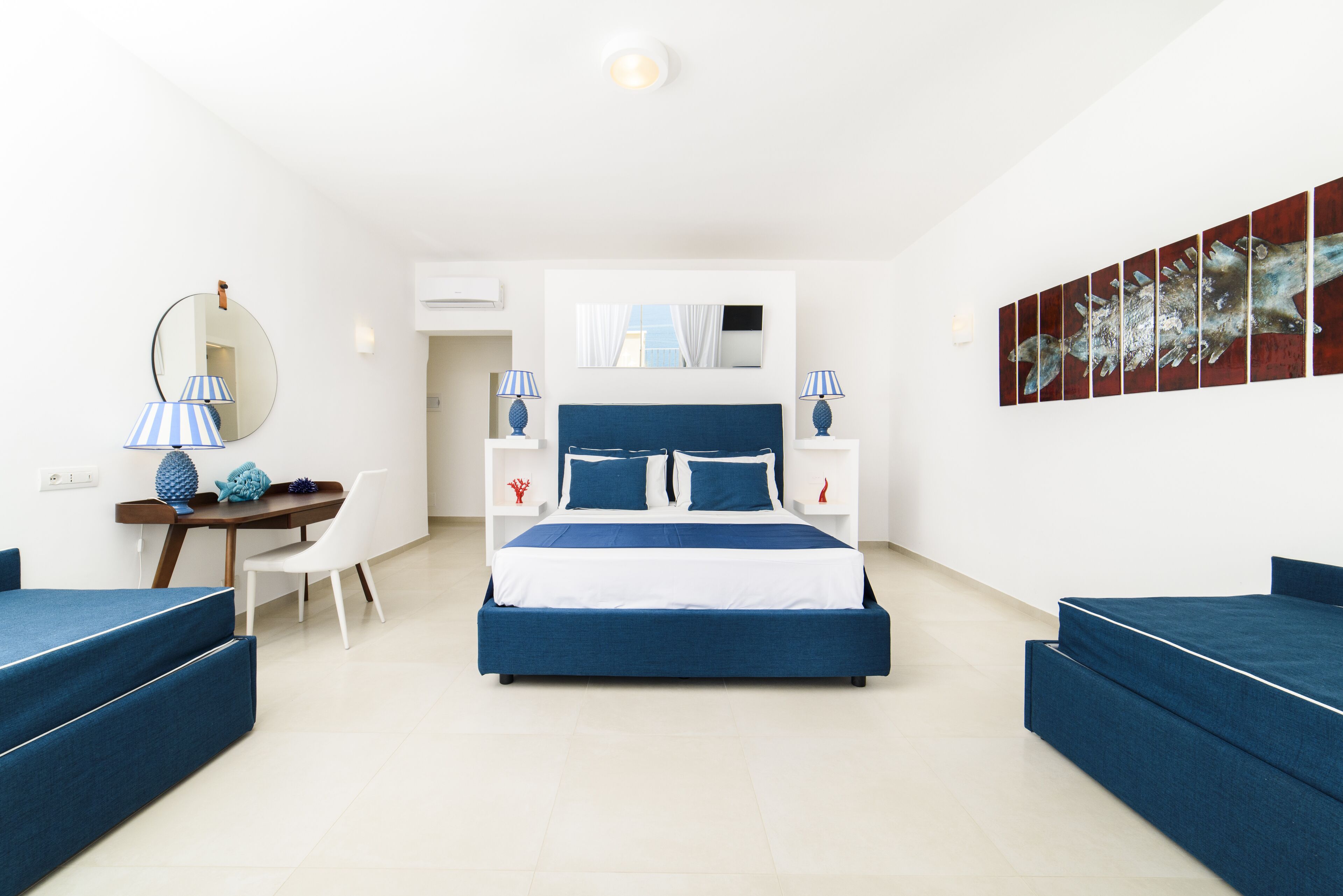 Un dormitorio moderno con una cama grande, mesitas de noche, un escritorio y una silla.