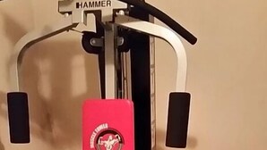 A gym with a red bench and a wall-mounted machine labeled "HAMMER". - Hostel zum Löwen (Todtmoos)
