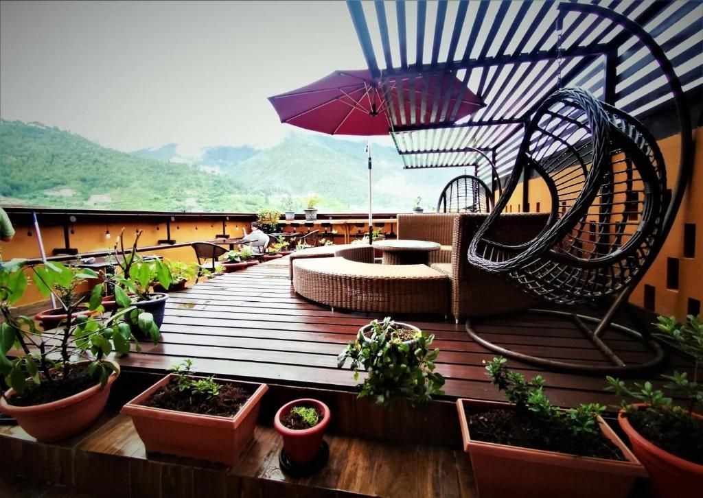 A wooden deck with potted plants, a circular seating area, and a spiral chair.