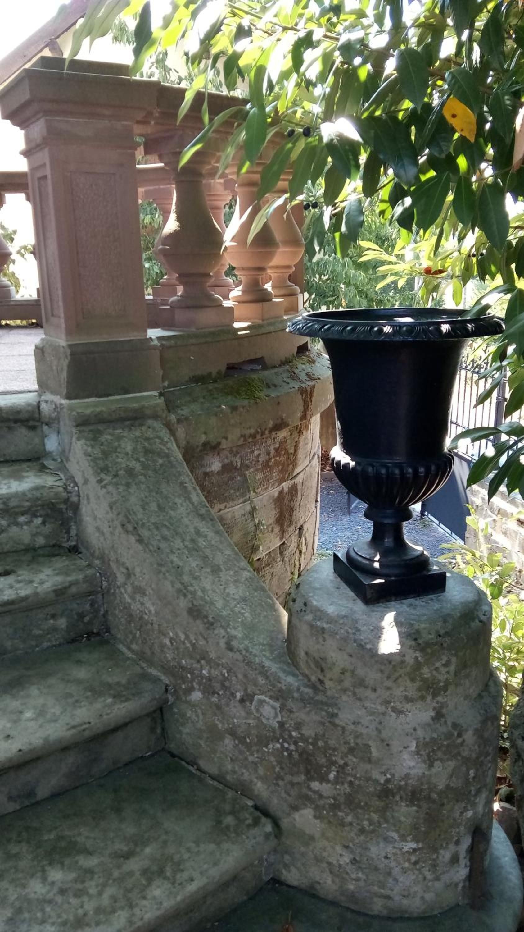Una scala in pietra con un'urna nera su un pianerotto.