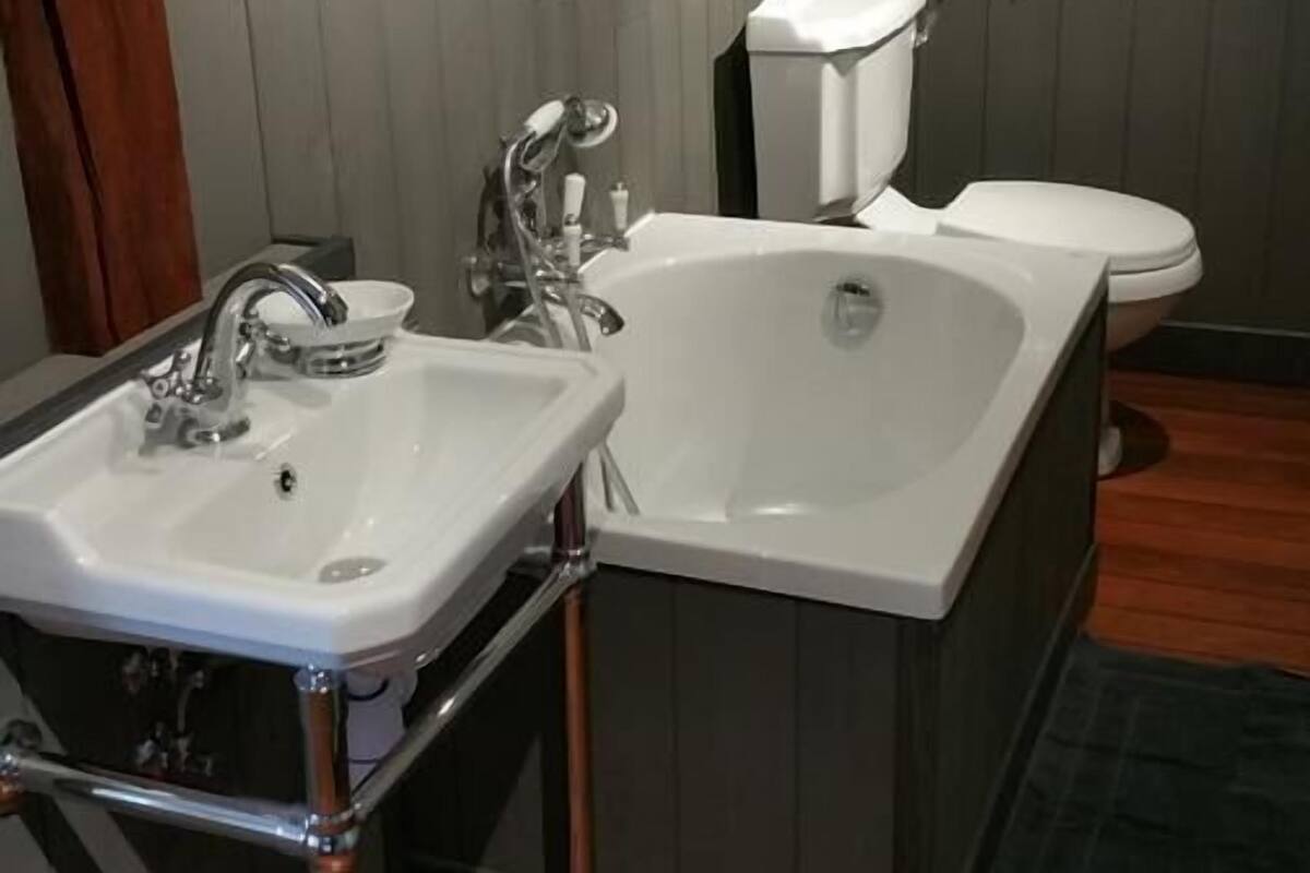 A bathroom with a white sink, a bathtub, and a toilet.
