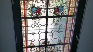 A stained glass door with floral patterns and a geometric design. - L' Obsidienne (Lixheim)