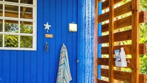 A blue building with a shower, a towel, and a star decoration.