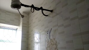 Une pièce dotée d’un ventilateur de plafond, d’une fenêtre avec des barreaux et d’un élément décoratif mural.