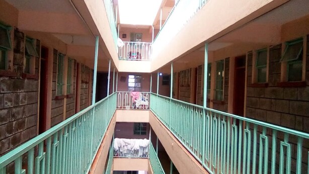 Un couloir à plusieurs niveaux, doté de balcons et de rampes.