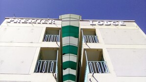 Un bâtiment dont la façade porte l’inscription « Premier Lodge ».