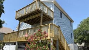 A two-story house with a wooden deck and a garage. - Bright & Beachy 3 bed/2 bath Soundside MP6 (Kill Devil Hills)