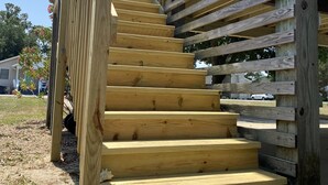 A wooden outdoor staircase leading to a deck area with a metal doormat at the bottom. - Bright & Beachy 3 bed/2 bath Soundside MP6 (Kill Devil Hills)