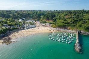 An aerial view of a coastal town with a beach, boats, and a pier. - My little house for two. (Plouézec)