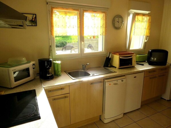 A compact kitchen with a microwave, coffee maker, sink, and a dishwasher. - My little house for two. (Plouézec)