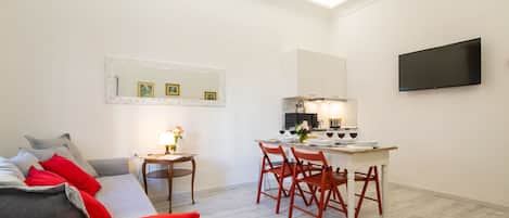 A modern apartment with a living area, a dining table, and a kitchen.