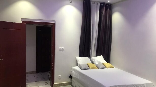 A bedroom with a bed, a wardrobe, and a door. - F2 UDDERS AT MAYAA (Ngor)