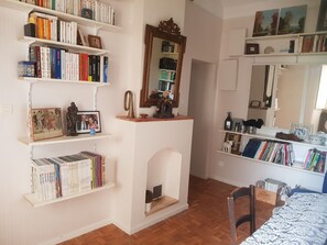 Cozy space for reading and relaxation, featuring a fireplace, bookshelves, and a dining table.