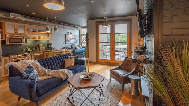 En moderne stue med sofa, sofabord og spiseområde med bord og stole.
