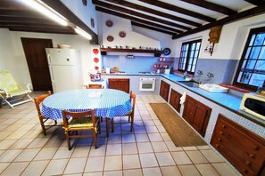 Enjoy meals in this cozy kitchen with a dining table for four, featuring a refrigerator, stove, and sink.