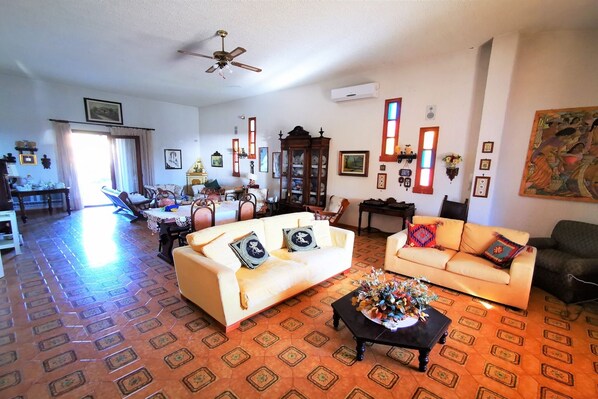 A spacious living room with two sofas, a coffee table, and a ceiling fan.