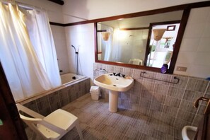 Tina con regadera, secadora de cabello, bidet, toallas 
