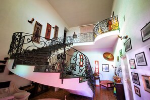Stunning multi-level space with a black wrought iron staircase and patterned flooring.