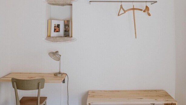 A minimalist room with a wooden desk, chair, and shelves. - La casa nel vicolo a Borgo Loretello (Loretello)