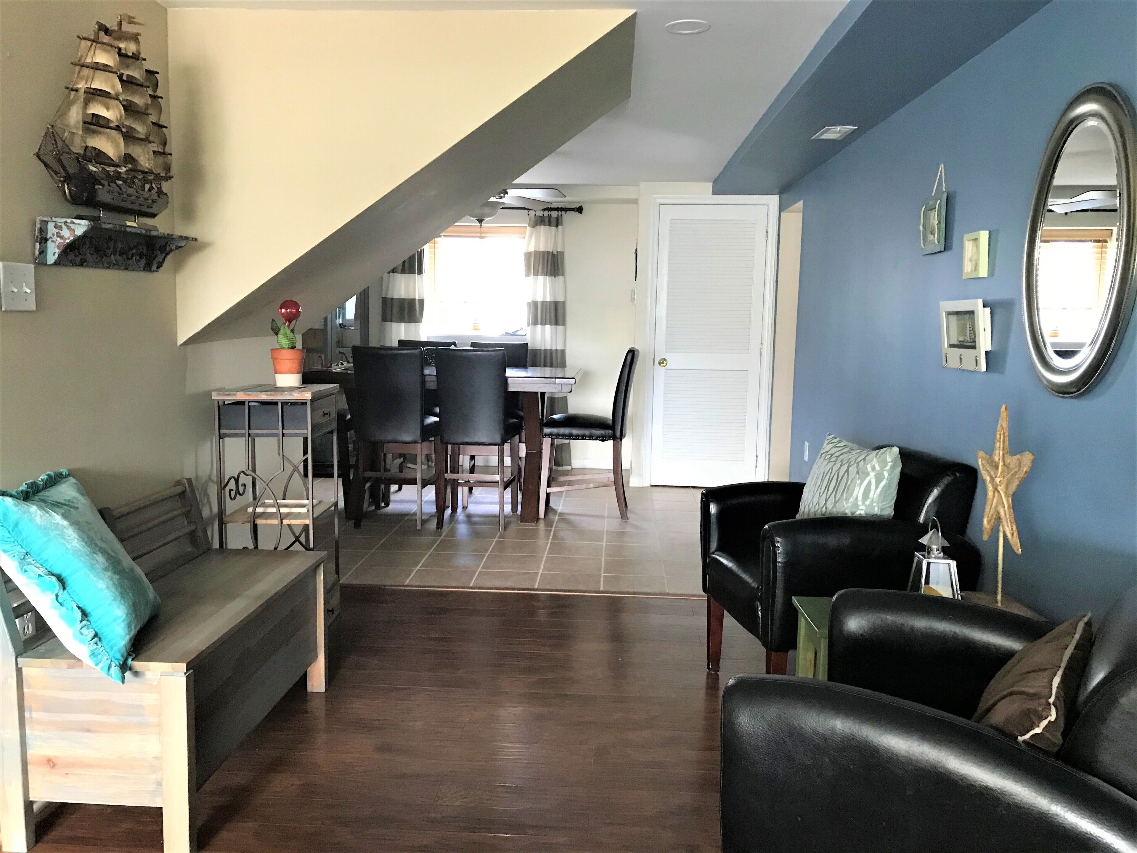 A living room with a sofa, a coffee table, and a dining area with chairs and a table.
