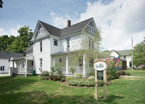 Standalone resort with a traditional gabled roof and front porch, surrounded by lush gardens.
