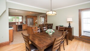 A spacious kitchen with wooden cabinets, a central island, and a dining area with a wooden table and chairs.