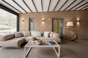 A modern living room with a sectional sofa, a coffee table, and a lamp.